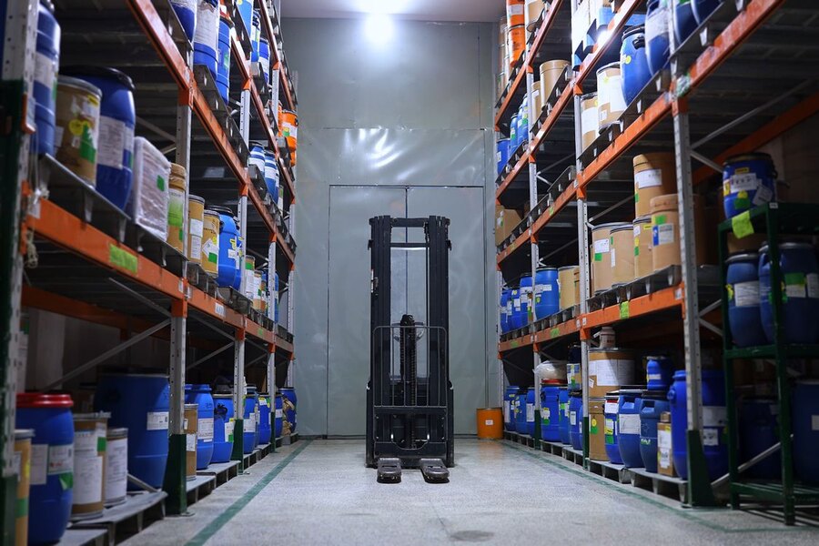 Organised warehouse aisle with storage racks and forklift